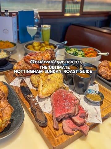 A high-angle, appetizing shot of a Sunday roast spread, including sliced beef, roast potatoes, vegetables, and gravy boats, presented on a wooden board.