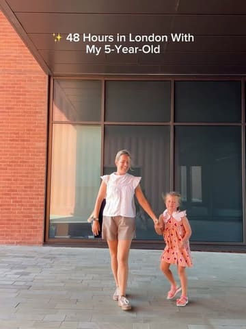 A bright, high-quality still from a travel reel showcasing a family-friendly itinerary in London, featuring a mother and child walking together.