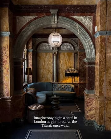 A beautifully composed, atmospheric photograph of an intimate seating nook within the Kimpton Fitzroy hotel, framed by an ornate, historic archway that highlights the venue's luxurious interior design.