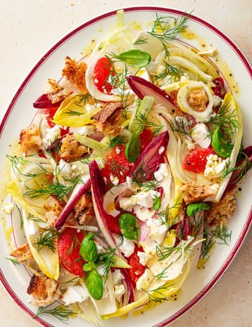 A high-quality, overhead food photography shot of a vibrant, fresh salad featuring shaved fennel, chicory, grapefruit segments, croutons, and fresh dill. The lighting is bright and even, highlighting the textures and colors of the ingredients, making for a highly appealing promotional image for a supper club event.