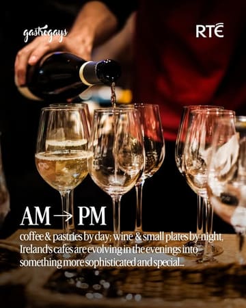 A high-quality, atmospheric image depicting a wine pour, used to promote a feature article about the evolution of Irish cafes into evening venues. The lighting is moody and professional, effectively setting a sophisticated tone for the subject matter.