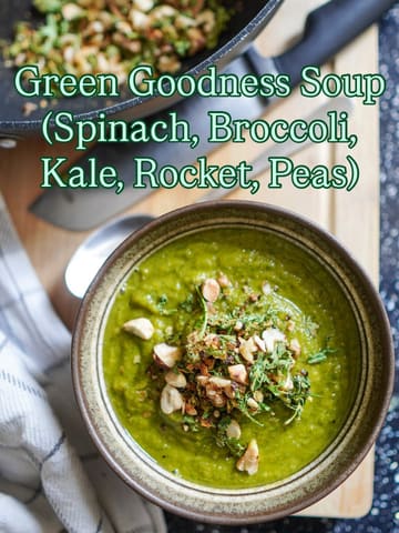 A high-quality, overhead shot of a vibrant green soup topped with nuts and herbs, presented in a rustic bowl on a wooden surface. The image is well-lit and styled, effectively showcasing the texture and freshness of the dish.