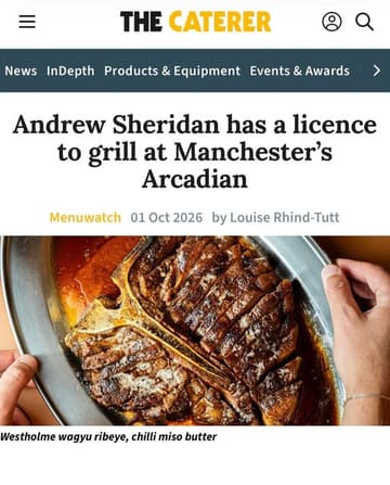 A professional, high-quality food photograph featuring a large, well-charred wagyu ribeye steak served on a metal platter. The image effectively communicates the fire-cooking concept of the restaurant, with the focus squarely on the quality and preparation of the meat.