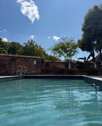 A bright, inviting photograph of a swimming pool at Hotel du Vin, Exeter, used to promote their 'dip & dine' spa and lunch package. The image focuses on the pool setting under a clear blue sky.
