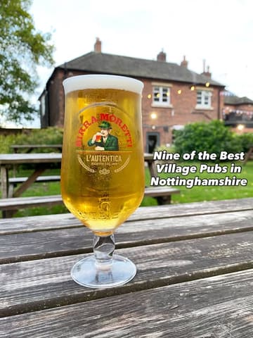A promotional image for a listicle featuring village pubs in Nottinghamshire, showing a pint of beer on a wooden picnic table with a pub in the background.