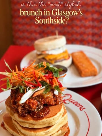 A high-quality, close-up shot of a stack of pancakes topped with fried chicken and slaw, with a breakfast muffin and hash brown visible in the background, set in a diner-style environment.