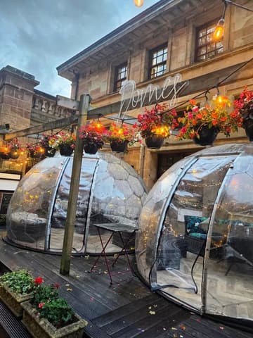 A photo of outdoor dining domes at The Duck 'n' Doc in Glasgow, showcasing the venue's exterior seating area with fairy lights.