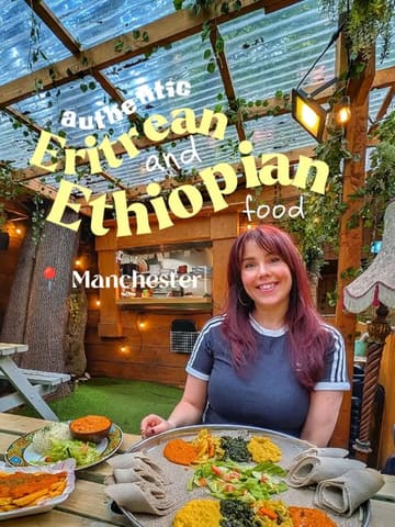 A social media-style photo featuring a creator posing with a large platter of Ethiopian and Eritrean food in an outdoor garden bar setting. The image is clearly intended for a review or recommendation post, highlighting the plant-based options available at the venue.
