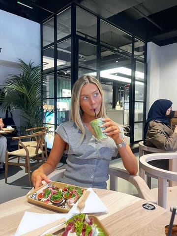 A lifestyle-focused shot of a creator enjoying a brunch spread at a cafe, featuring fig and feta toast and specialty lattes.