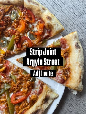 A top-down shot of a Cajun chicken pizza, heavily obscured by a large, central text overlay promoting the venue and the nature of the post.