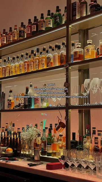 A static, eye-level shot of a well-stocked bar shelf featuring a collection of Japanese whiskies, presented as part of a series of venue recommendations in Manchester.
