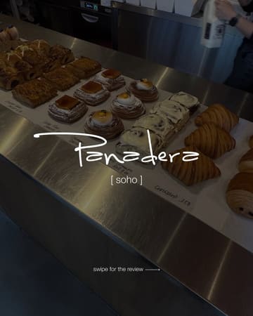 A casual, point-of-view style shot of a bakery counter display in a cafe, featuring various pastries like danishes, cinnamon rolls, and croissants.