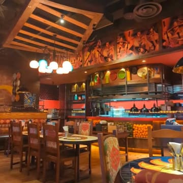 A wide-angle, eye-level shot of the interior of a Chiquito restaurant, showing the dining area with tables, chairs, and themed decor.