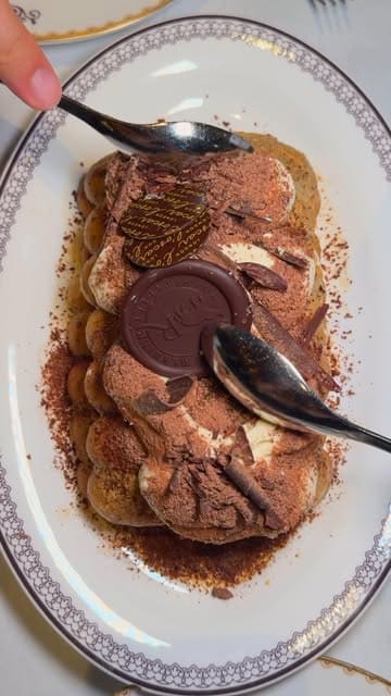 A visually polished montage showcasing the opulent interior of L'oscar London, a restaurant set in a former church, followed by a series of high-end dishes including wagyu crispy rice, a crudo platter, black cod, and a table-side tiramisu service.