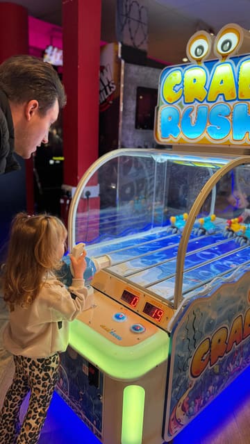 A family-focused vlog documenting a day out at a venue featuring bowling, arcade games, and a Pan-Asian restaurant. The video transitions from the activity area to a sit-down meal, highlighting the variety of experiences available under one roof.