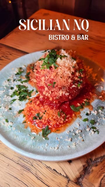 A review of Sicilian NQ, a neighborhood bistro and bar, showcasing their authentic Sicilian dishes including arancino, bruschetta, cannelloni, seafood ravioli, and various cakes, along with cocktails.