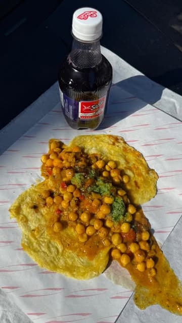 A review of Moto Roti in Acton, featuring a variety of Trinidadian street food dishes like doubles, bakes, and goat roti. The creator provides context on the dishes and highlights the freshness of the preparation.