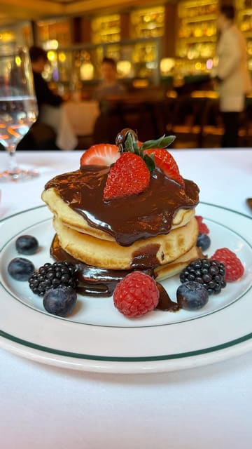 A short, polished montage showcasing the brunch menu at Smith & Wollensky, featuring close-ups of pancakes, beef brisket with Yorkshire pudding, and hash browns, set within the restaurant's interior.