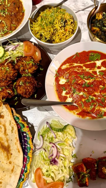 A vlog-style review of Kumars Kitchen in Bedford, featuring a variety of Indian and Pakistani dishes including butter chicken, tandoori salmon, and lamb dansak.