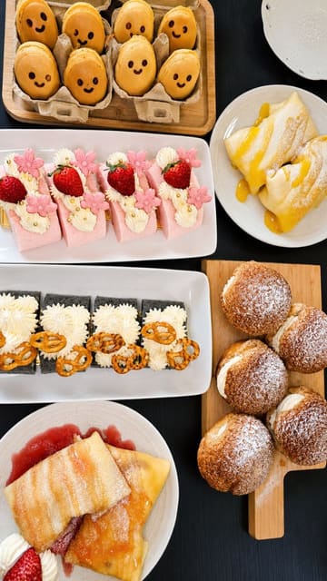 A review of Candy's Dream Cake in Aberdeen, featuring a variety of savoury dishes like dandan pork noodles, Hong Kong hotdogs, and panko prawns, followed by an extensive selection of cakes and pastries including mango pancakes, strawberry cream cake, and matcha/black sesame cakes. The video highlights the warm atmosphere and the community connection through a wall of customer messages.