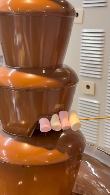 A vlog-style video showcasing a visit to Little Cosmo, an all-you-can-eat buffet restaurant. The video features shots of the entrance, the various food stations, the plating of dishes like duck pancakes and ribs, and the dessert section including a chocolate fountain and ice cream.