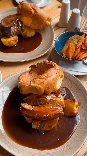 A montage video showcasing a Sunday roast meal at The Stables, Beamish Hall. The video features close-up shots of various roast meats, Yorkshire puddings, sides like cauliflower cheese, and desserts, alongside shots of the venue's interior and exterior.
