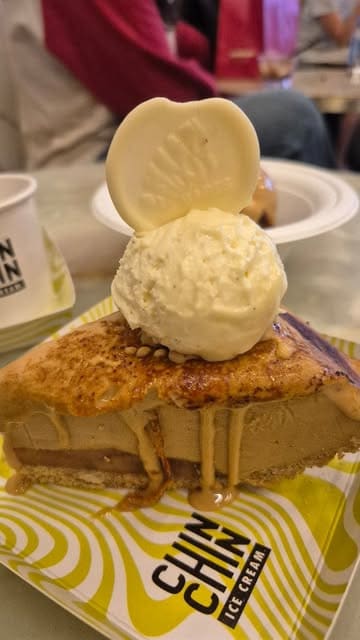 A high-quality, close-up video showcasing the preparation of a banoffee ice cream pie at Chin Chin Ice Cream. The clip features the torching of the caramelised top, the addition of a scoop of tonka bean ice cream, and the placement of a chocolate garnish.