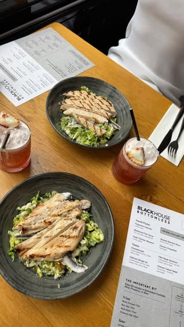 The creator visits Blackhouse in Leeds for a bottomless brunch, highlighting the variety of cocktails and the quality of the food menu, which includes small plates and mains. The video features shots of the venue, the menu, various cocktails, and dishes like anchovies and caesar salad.