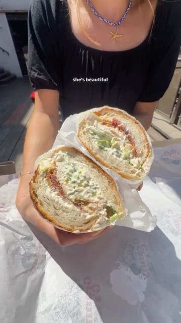 Two creators visit a sandwich pop-up called Granny G's located at the Green Room in Leeds. They showcase the menu, the venue's outdoor terrace, and review two of their sandwiches: the Chicken Caesar and the Shrimp Po Boy. The video is a high-energy, informative review that highlights the quality and portion size of the food.