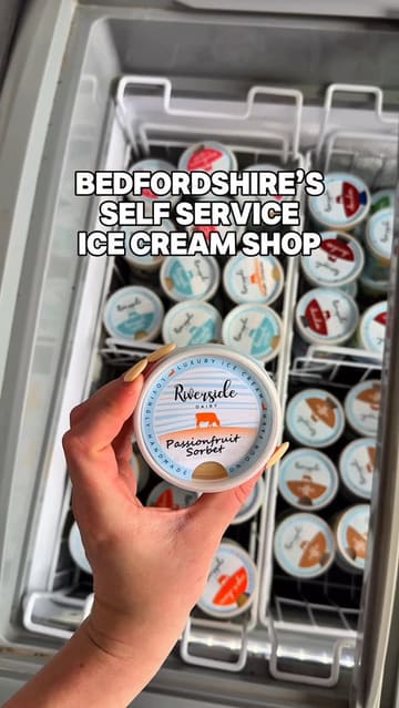 A short, first-person tour of 'The Ice Cube' at Riverside Dairy, a self-service ice cream shop in Bedfordshire. The video highlights the variety of ice cream and sorbet flavours available, the payment process, and the outdoor seating area.