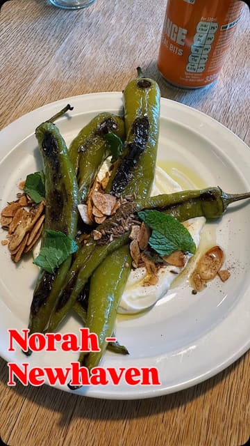 A review of Norah in Newhaven, Edinburgh, showcasing the venue's atmosphere, menu, and various dishes including asparagus, sausages, and dessert.