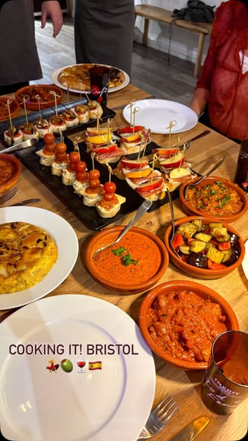 The video provides a tour of a Spanish tapas and pintxos cooking class at Cooking It! in Bristol. It captures the process from preparation and cooking to the final spread of dishes, highlighting the social and hands-on nature of the experience.
