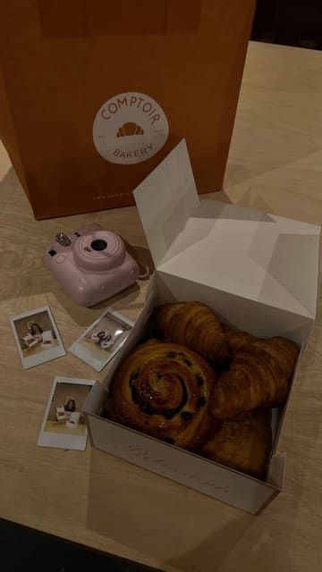 A vibrant, fast-paced reel documenting a pastry-making workshop at Comptoir Bakery School. The video follows the creator through the process of kneading, shaping, and baking various French pastries, highlighting the interactive and beginner-friendly nature of the class. It concludes with the finished products and the takeaway box, effectively selling the experience as a fun activity.