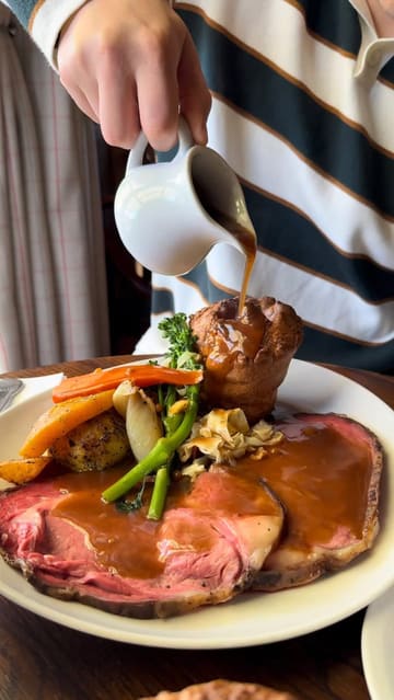 A travel vlog showcasing a stay at The Flower Pot Hotel, featuring the hotel's cosy rooms, scenic riverside location, pub garden, and dining experience including a Sunday roast.