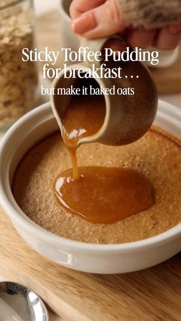 A short, aesthetic recipe video demonstrating how to make sticky toffee pudding baked oats. The video uses close-up shots to show the blending of ingredients, the baking process, and the final pouring of the sauce.