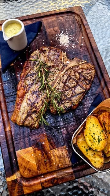 A short, polished montage showcasing a new Italian restaurant in Bath, featuring close-ups of dishes like T-bone steak, burrata, tiramisu, and cheesecake, alongside shots of the interior and outdoor seating area.