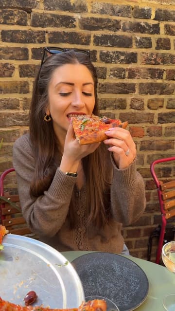 A short video showcasing a pizza restaurant's terrace, menu, and food items like pizza and eggplant parmigiana.