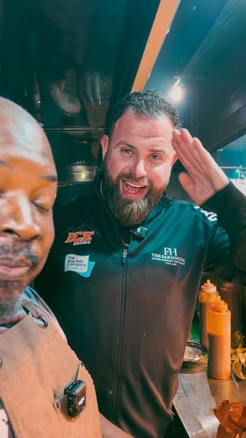 A food review video featuring the Food Review Club visiting Joey's Smokehouse. The creator and the owner discuss the quality of the smoked meat, specifically a large beef rib, emphasizing its tenderness. The video is shot in the kitchen area, providing a behind-the-scenes look at the food preparation.