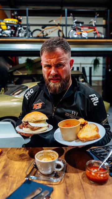 A review of a unique venue in Cambridge that combines a car workshop with a cafe, featuring a breakfast bap and a chili cheese toastie.