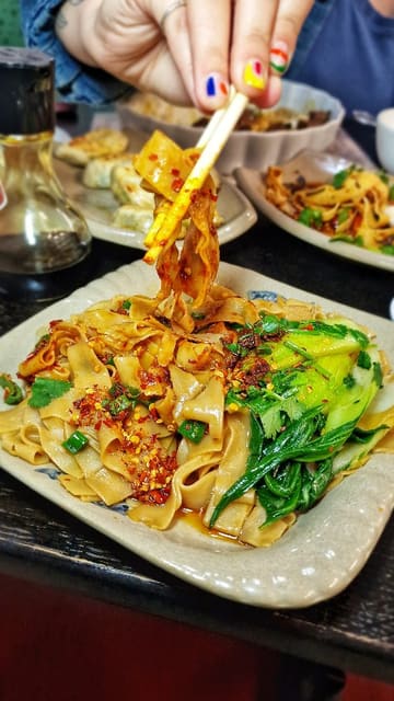 A short-form video review of 'Eat & Sip Market', a small eatery located inside an Asian grocery store in Cardiff. The video features close-up shots of various Chinese dishes, including noodles, dumplings, bao, and omurice, alongside shots of the grocery store aisles, effectively showcasing the unique 'hidden gem' atmosphere.