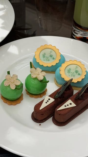 A high-quality vlog showcasing a Bridgerton-themed afternoon tea experience at The Lanesborough hotel in London. The video highlights the elegant venue, the themed tea service, and close-ups of the sandwiches, scones, and intricate pastries.
