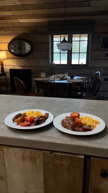 A short, aesthetic montage showcasing a cosy autumn staycation at a lodge, featuring scenes of a bathtub, a fireplace, a bedroom, and a breakfast spread.