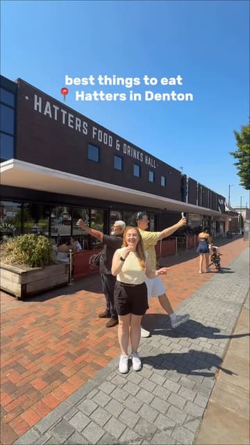 A group of three creators visits Hatters Food & Drinks Hall in Denton, showcasing a variety of dishes from four different independent kitchens located within the venue. The video uses a fast-paced, vlog-style format to highlight specific menu items from each vendor, including waffles, pizza, burgers, and paella.