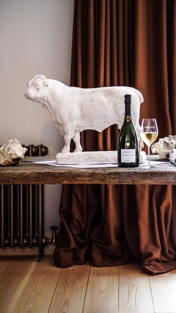 A cinematic montage showcasing the Ashcombe Estate, featuring luxury accommodation, scenic countryside views, and an open-fire dining experience at WildKitchen, paired with Bollinger champagne.
