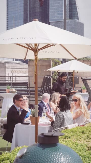 A montage showcasing a rooftop dining experience at Coq d'Argent in partnership with Mirabeau rosé. The video features shots of the venue setup, staff service, guests enjoying wine and food, and the London skyline.