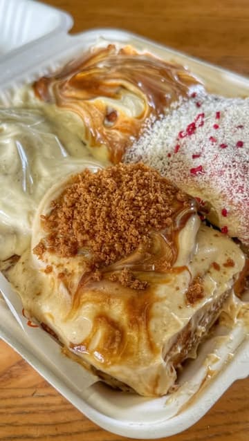 A short, energetic reel showcasing a popular cinnamon bun vendor at a pop-up location. The video features close-up shots of the loaded buns, a queue of customers, and the vendor preparing the food, effectively highlighting the product's popularity and appeal.