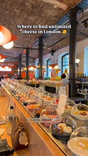 A short, engaging video showcasing the 'bottomless cheese' experience at Pick & Cheese in Seven Dials Market, London. The video highlights the conveyor belt service, the variety of cheese plates, and the unique pairings available.