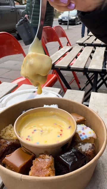 A short promotional video showcasing the 'Double Dipper' dessert platter at The Cuppie Hut in Norwich, featuring various cakes served with a pot of warm custard.