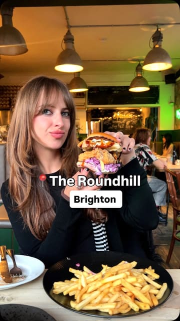 A vibrant review of The Roundhill in Brighton, a 100% vegan pub. The creator takes the viewer through a variety of dishes, including burgers, small plates, and cocktails, highlighting the quality and variety of the plant-based menu.