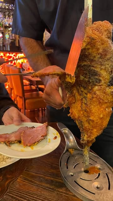 A vlog-style review of a Brazilian rodizio restaurant in Liverpool, showcasing the salad bar, various cuts of meat being carved at the table, and the overall dining experience.